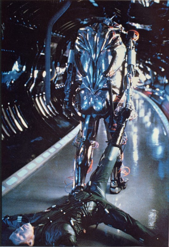 Hector drags his maker's body away in a reversal of his namesake's fate in the original legend of Achilles. This production still is notable in that it is a rare rear view of the robot's anatomical design.